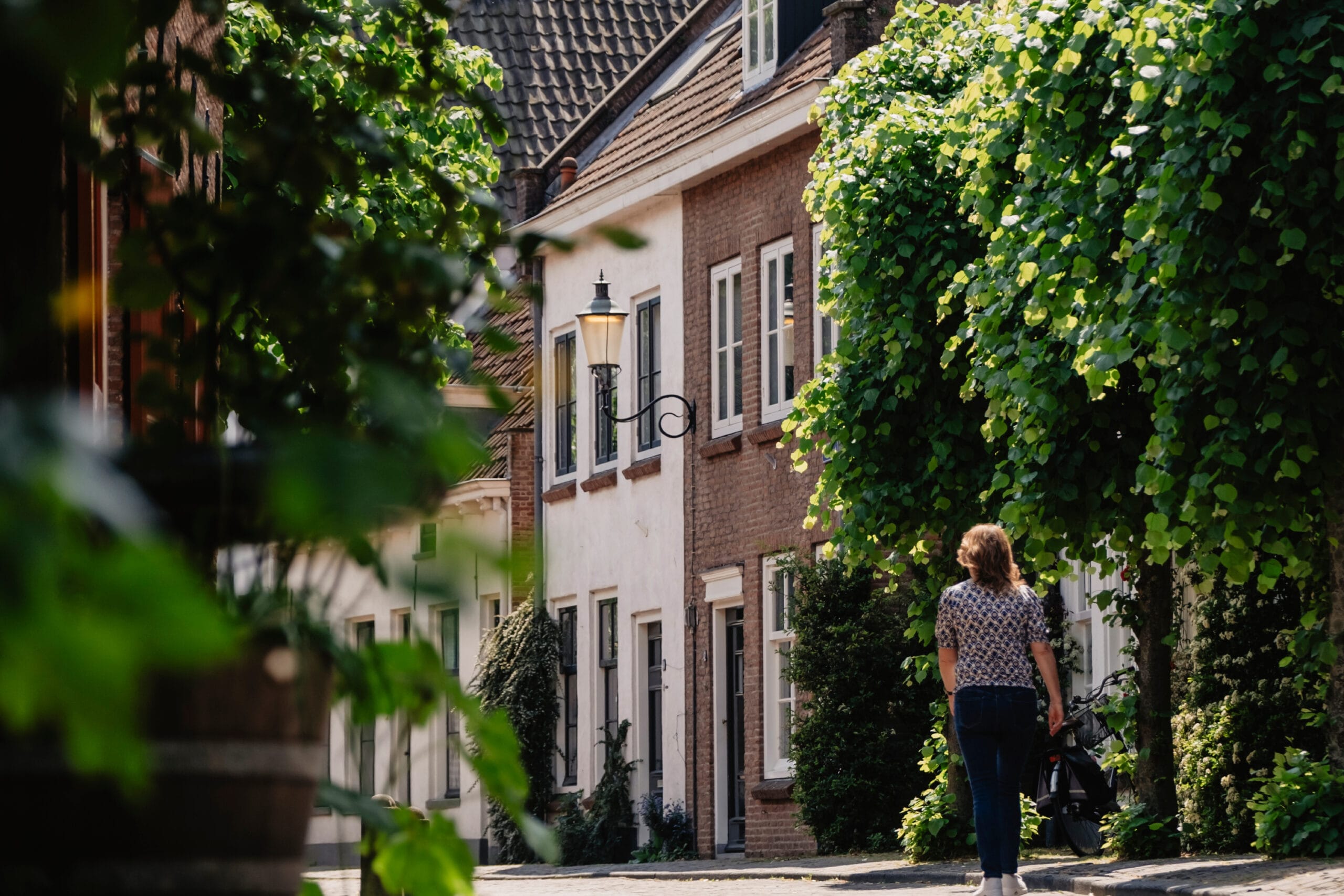 Vrouw op zoek naar de aankoop van een woning. Tijdens wandeling aan het nadenken over het aankoopproces.